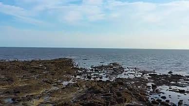 航拍倒飞晴朗天空下的大海沙滩视频的预览图
